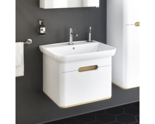 Weißer Waschtisch mit Armatur, Seifenspender und Handtuchhalter im Badezimmer.
