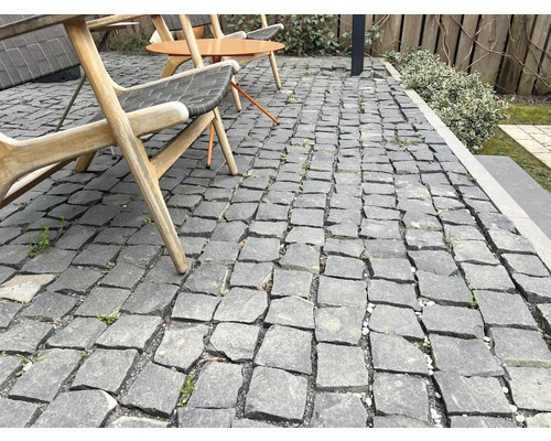 Außenbereich mit Granitpflastersteinen, Sitzgelegenheiten und Gartenelementen.