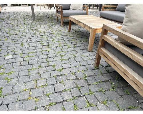 Außenbereich mit Pflastersteinen und Gartenmöbeln aus Holz