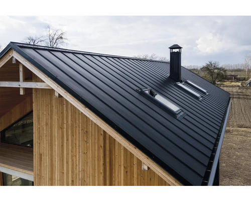 Ansicht eines Hauses mit Metalldach, Dachfenstern und Schornstein