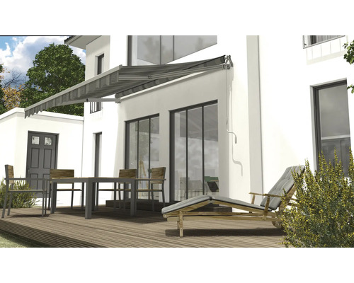 Hausfassade mit Markise, Gartentisch und Liegestuhl auf Holzterrasse