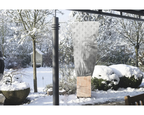 Winterlandschaft mit Pflanzschutztasche über einer Pflanze
