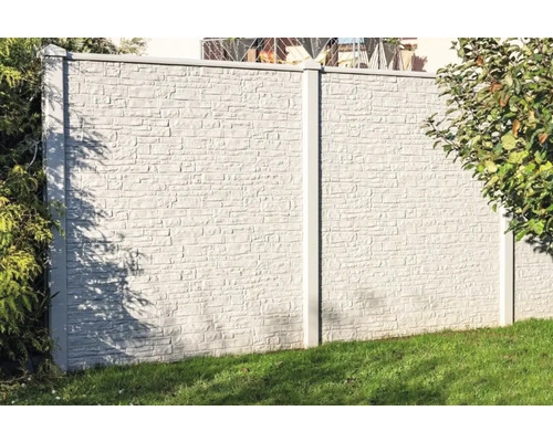 Betonzaun mit Steinmuster zur Grundstücksbegrenzung