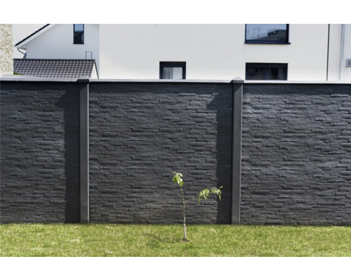 Steinmauer mit Betonpfosten und Gras im Garten