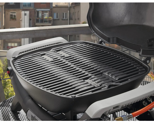 Weber Gasgrill mit Grillrost und geöffnetem Deckel.