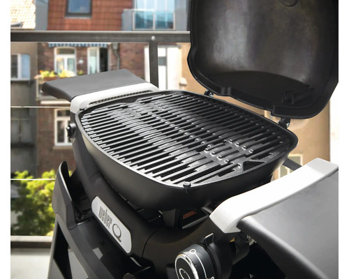 Weber Q Grill mit geöffnetem Deckel auf einem Balkon.