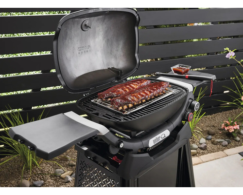 Weber Grill mit Rippchen auf dem Grillrost im Garten.