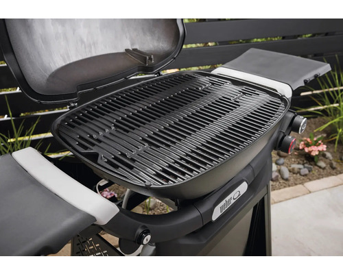 Weber Grill mit offenem Deckel und Grillrost.