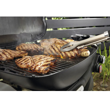 Grill mit Steaks und Grillzange