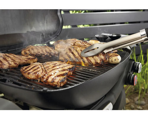 Grill mit Steaks und Grillzange