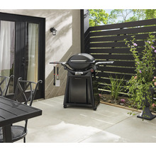 Außenbereich mit Kugelgrill, Grillbesteck und Gartentisch auf einer Terrasse