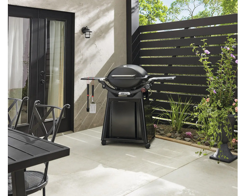 Außenbereich mit Kugelgrill, Grillbesteck und Gartentisch auf einer Terrasse