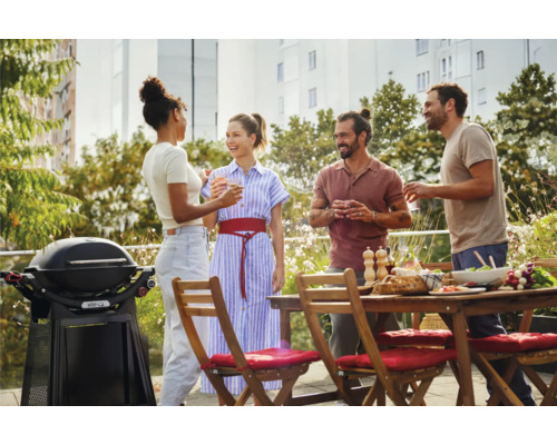 Szene mit Grill, Gartentisch und vier Personen bei einer Gartenparty.