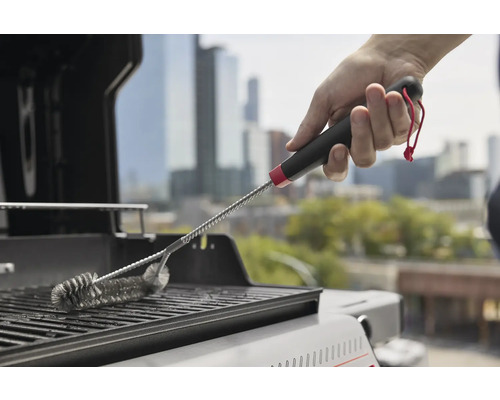 Eine Grillbürste wird verwendet, um einen Grill zu reinigen.