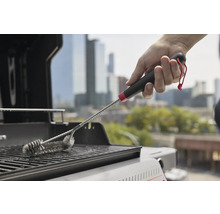 Grillbürste in Verwendung auf einem Grillrost