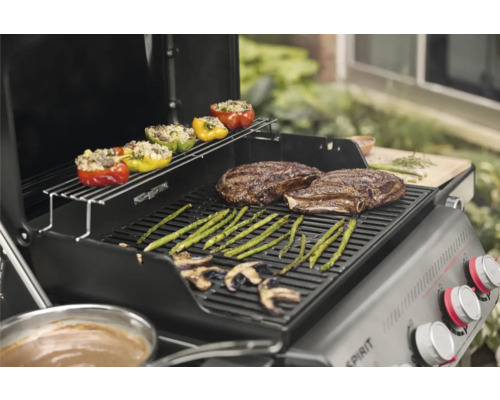 Grillszene mit gefüllten Paprika, Spargel, Pilzen und Steaks auf einem Grill