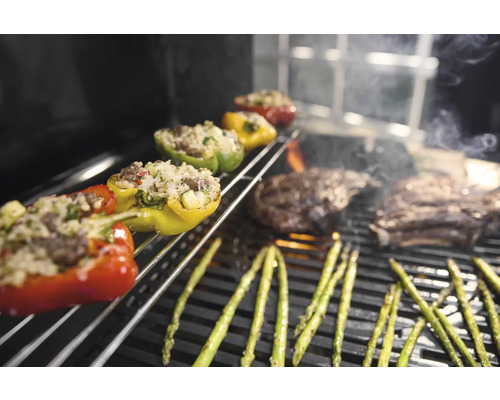 Gefüllte Paprika, Spargel und Steaks auf einem Grill