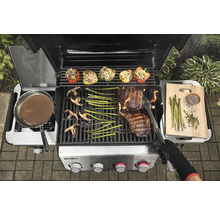 Gasgrill mit Grillgut wie Steak, Gemüse und gefüllten Paprika.