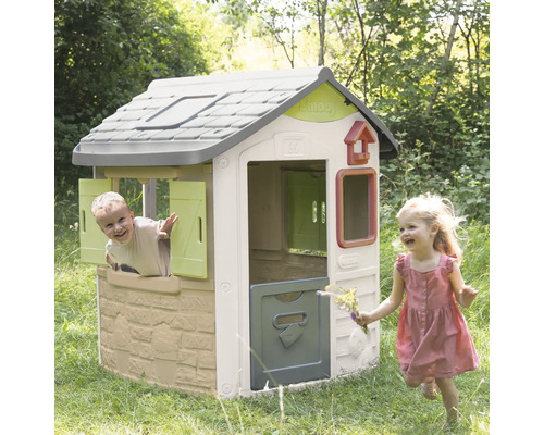 Kinderspielhaus im Garten mit spielenden Kindern