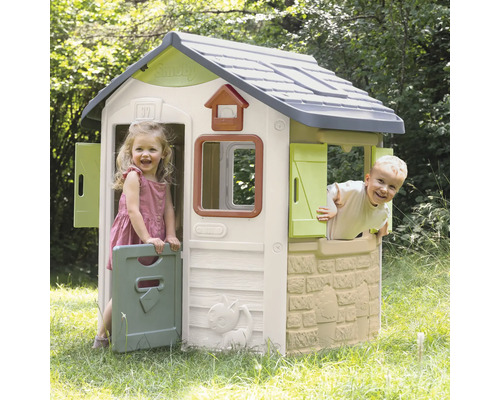 Kinder spielen in einem Smoby Spielhaus im Garten.