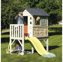 Kinder spielen in einem Smoby Kletterhaus mit Rutsche im Garten.