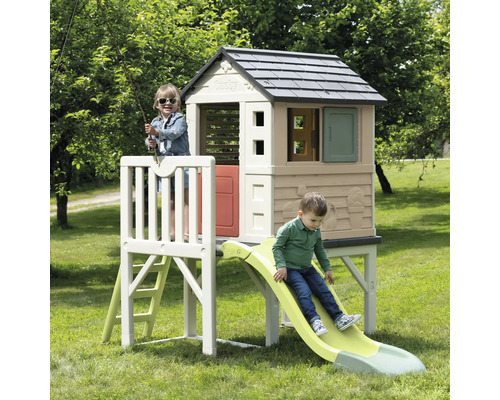 Spielhaus mit Rutsche und zwei Kindern im Garten.