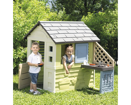 Spielhaus mit zwei Kindern im Garten.