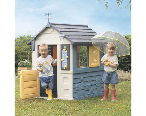 Spielhaus mit zwei Kindern im Garten.