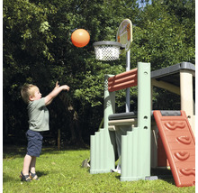 Junge wirft einen Ball in einen Basketballkorb an einem Spielturm im Garten