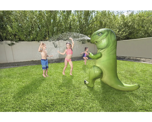 Szene im Freien mit Kindern, die mit einem aufblasbaren Dinosaurier-Wassersprenger spielen