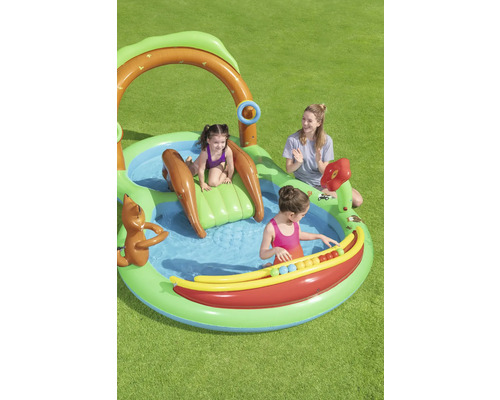 Aufblasbares Kinderspielcenter mit Wasserrutsche und Wasserspielen im Garten mit spielenden Kindern und einer Frau.