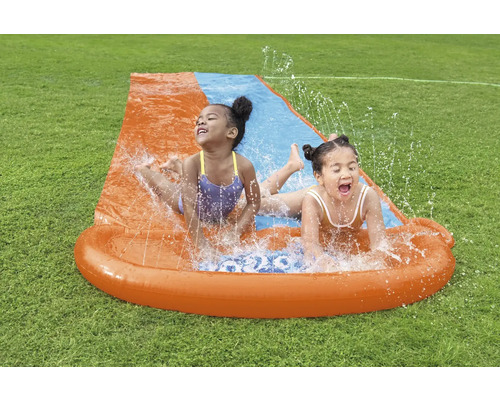 Zwei Kinder haben Spaß auf einer Wasserrutsche im Garten.