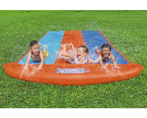 Wasserspielbahn mit drei Kindern im Garten auf Rasen