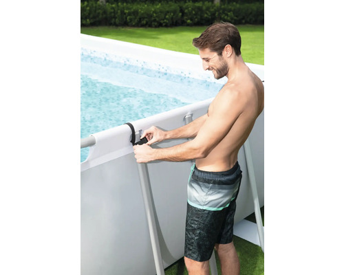 Mann befestigt Poolfolie an einem Frame Pool