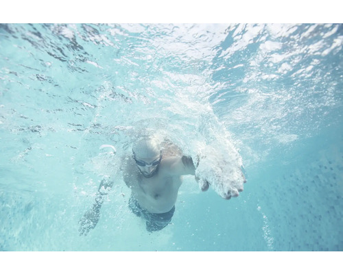 Mann schwimmt im Pool unter Wasser
