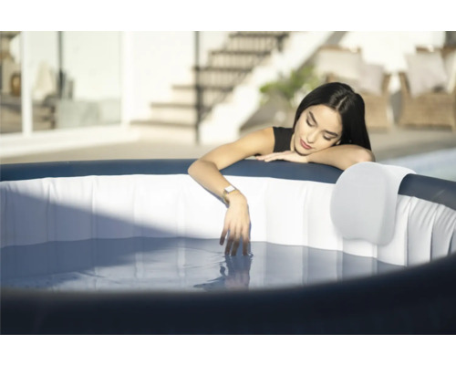 Frau entspannt in einem aufblasbaren Whirlpool im Garten.