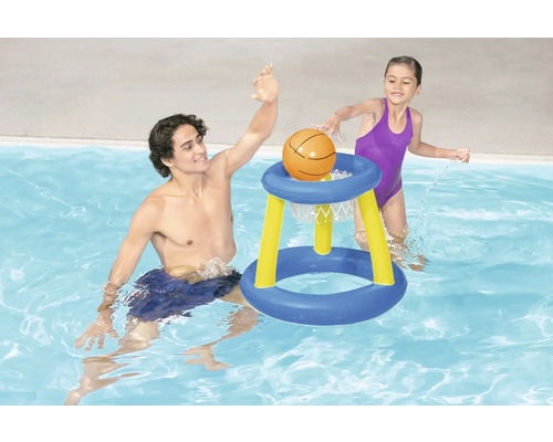Mann und Kind spielen mit einem Basketballkorb im Schwimmbad.