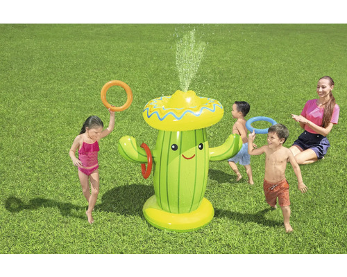 Aufblasbarer Kaktus Wassersprinkler mit Kindern und Erwachsenen beim Ringewerfen im Garten.