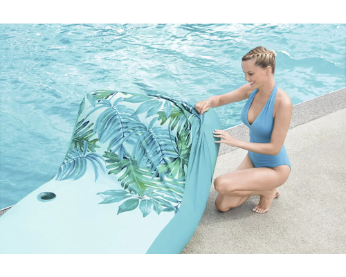 Aufblasbare Pool-Liege mit Blättermuster und einer Frau am Pool