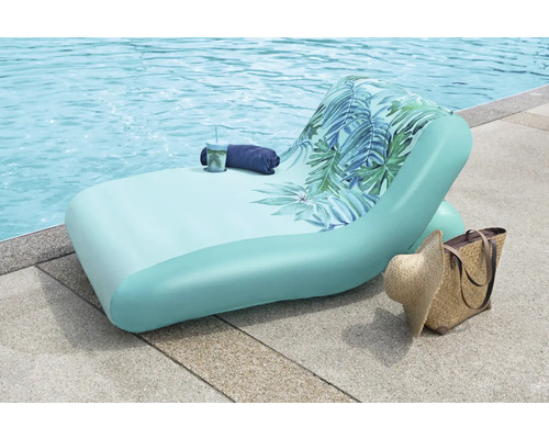 Aufblasbare Liege mit tropischem Muster am Pool mit Tasche und Hut.