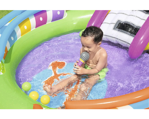 Kind im bunten Planschbecken mit Wasserrutsche und Spielbällen