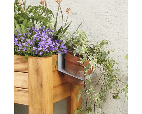 Nahaufnahme einer Holzkonstruktion mit Blumenkasten und Halterung für einen Blumentopf mit Efeu
