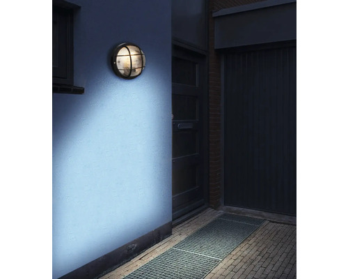 Runde Wandleuchte mit Gitter an einer Wand montiert