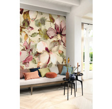 Wohnzimmer mit Wandtapete mit Blumenmuster, Sofa mit Kissen und Beistelltischen.