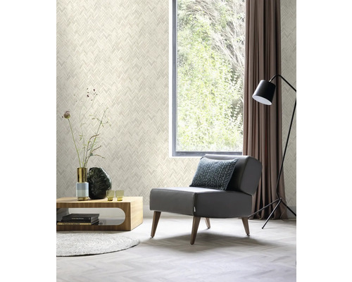 Wohnzimmer mit gemusterter Tapete, Sessel, Tisch und Fenster mit Vorhang.