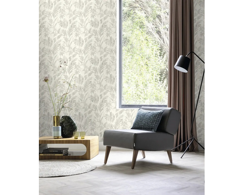 Helles Wohnzimmer mit gemusterter Tapete, Sessel, Tisch und Fenster