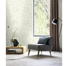 Heller Wohnraum mit Sessel, Tisch, Stehlampe, Vorhang und floral gemusterter Tapete
