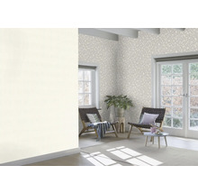 Heller Raum mit gemusterter Tapete, Sesseln und Zimmerpflanze