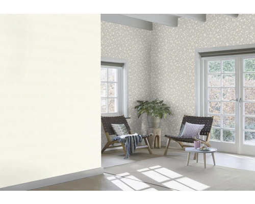 Heller Raum mit gemusterter Tapete, Sesseln und Zimmerpflanze