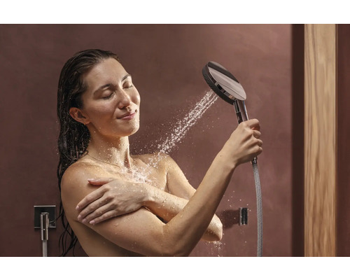 Frau unter der Dusche mit Handbrause und Wasserdüsen